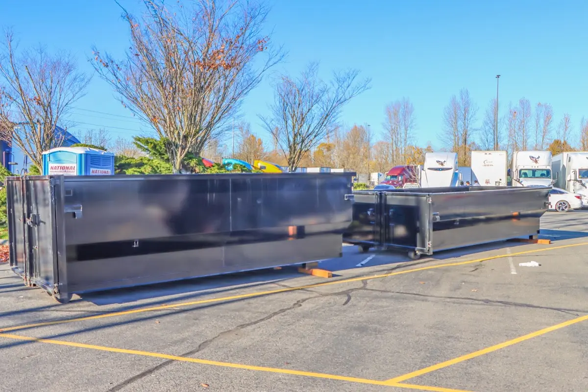 Professional dumpster rental service with roll-off container on residential driveway in Huntsville